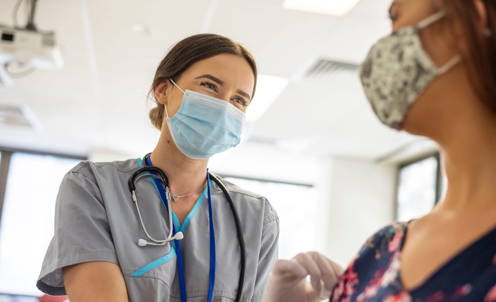 Friendly-nurse-preps-patient-prior-to-COVID-19-vaccine-shot-aspect-ratio-1600-975